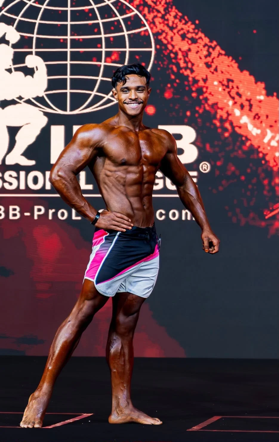 Mohamed Ahizoune posing on a bodybuilding competition stage